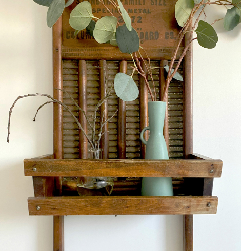 Estantería rústica con jarra de cerámica azul, eucalipto y elementos decorativos