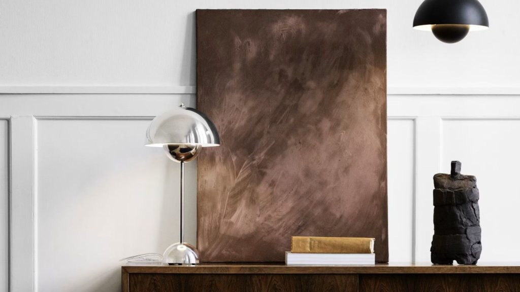 Espacio minimalista con cuadro artístico marrón, lámpara de pie y objetos decorativos